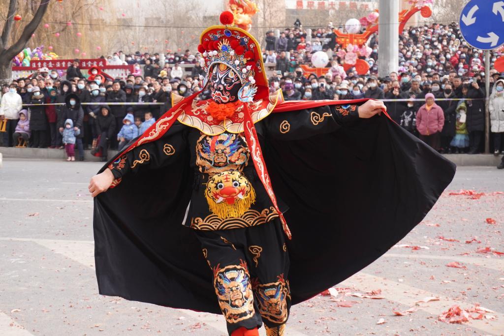 2月20日，在榆中县中心广场，红寺村社火队队员表演变脸。新华社记者　马希平　摄