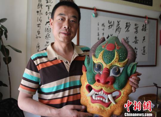 甘肃工艺师传承傩面艺术雕刻远古传说中百张“面孔”