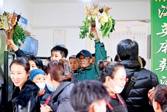 3月14日，甘肃天水，游客手举挑选的麻辣烫食材。摄影/本刊记者 九美旦增